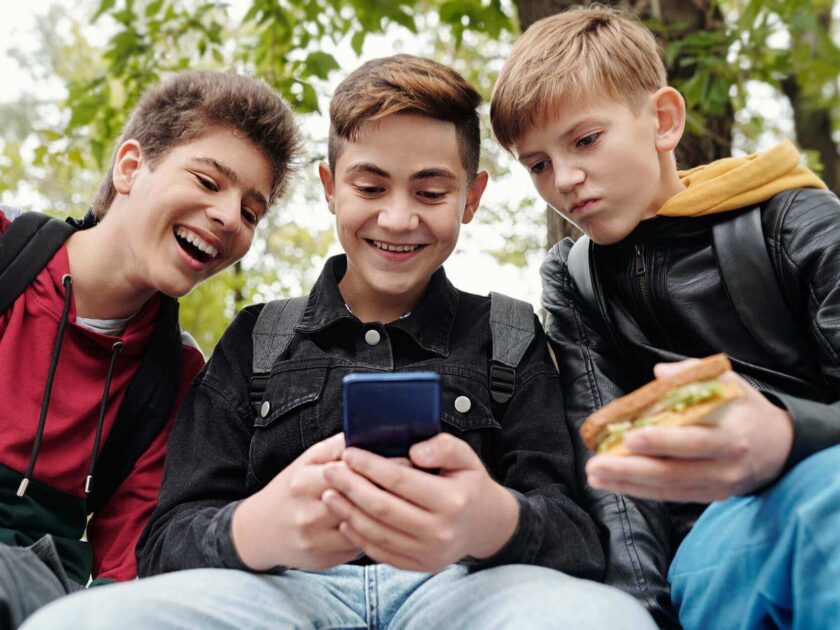3 Jungen sioilen an Ihrem Smartphone