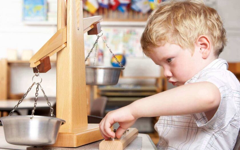 Junge in einer Montessori-Kita erprobt eien Waage