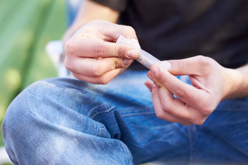 Ein Jugendlicher dreht sich eine Cannabis-Zigarette