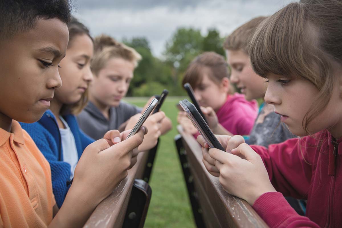 Kein Social Media für Kinder unter 13 Jahren - KInder konzentrieren sich auf ihr Smartphone